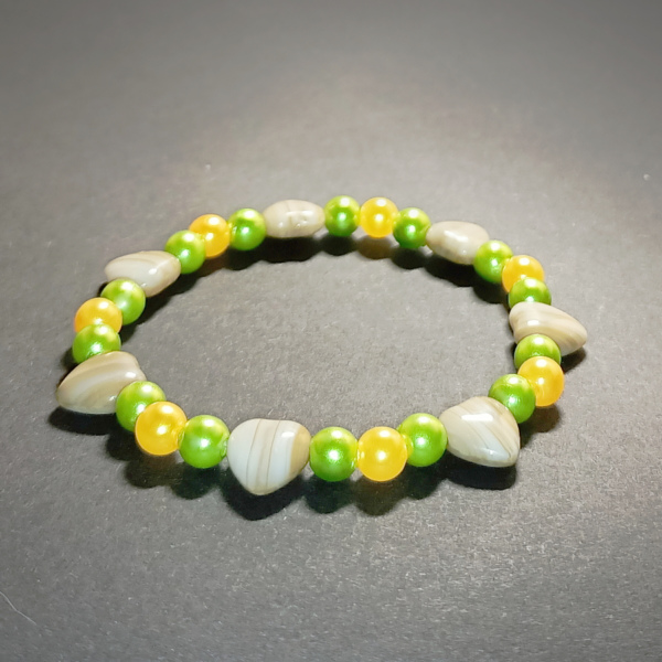 Bransoletka damska - koraliki perełki żółte i zielone oraz serduszka z kamienia szklanego